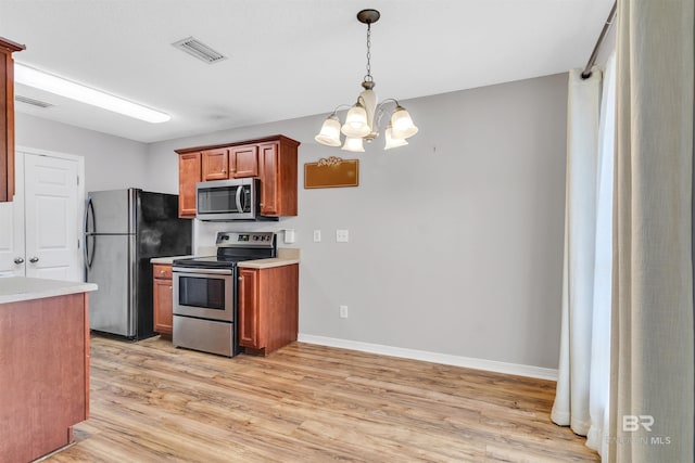 kitchen with pendant lighting, light wood-type flooring, a notable chandelier, and appliances with stainless steel finishes