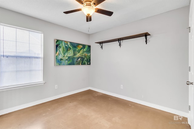 unfurnished room featuring ceiling fan, plenty of natural light, and concrete flooring