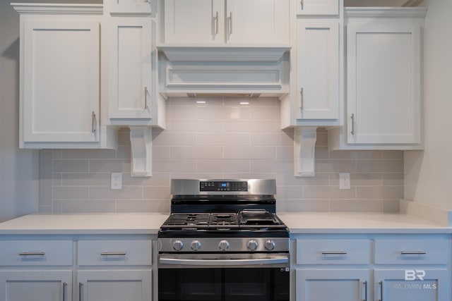 kitchen featuring white cabinets, gas range, backsplash, and custom exhaust hood