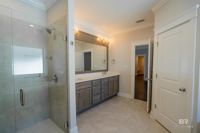 bathroom featuring tile patterned floors, vanity, a shower with shower door, and ornamental molding