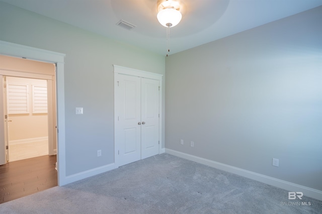 unfurnished bedroom with carpet floors, a closet, and ceiling fan