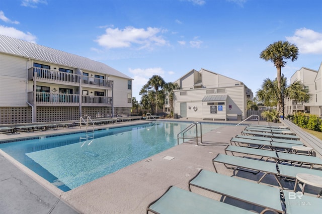 community pool with a patio and fence