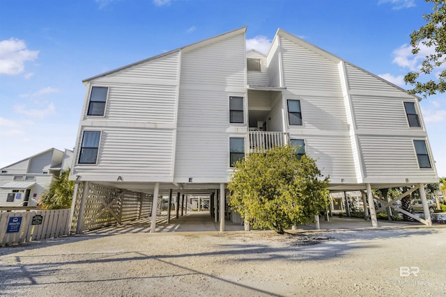 view of building exterior featuring a carport, driveway, and stairs