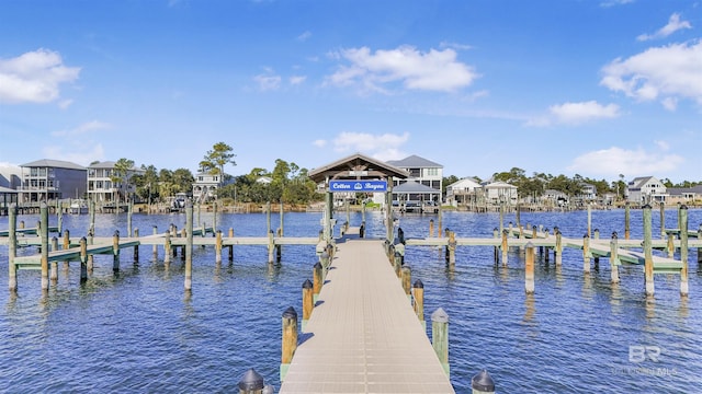 view of dock with a water view, boat lift, and a residential view