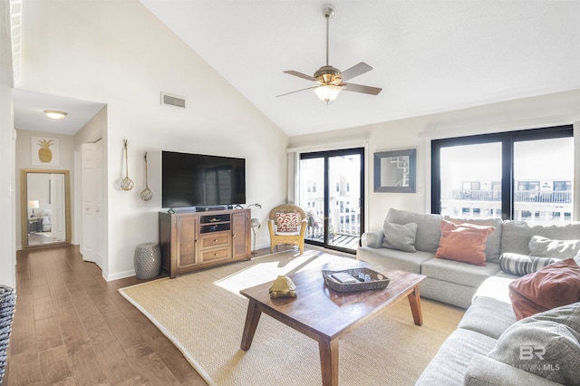 living area with ceiling fan, high vaulted ceiling, wood finished floors, visible vents, and baseboards