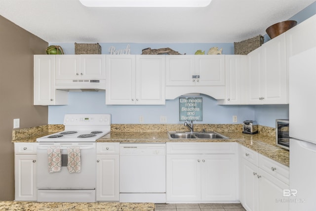 kitchen featuring light stone counters, white cabinets, a sink, white appliances, and under cabinet range hood