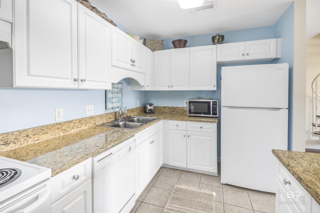 kitchen with visible vents, white cabinets, a sink, light tile patterned flooring, and white appliances