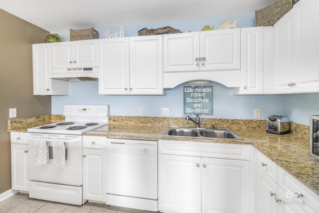 kitchen with white appliances, white cabinets, a textured ceiling, under cabinet range hood, and a sink