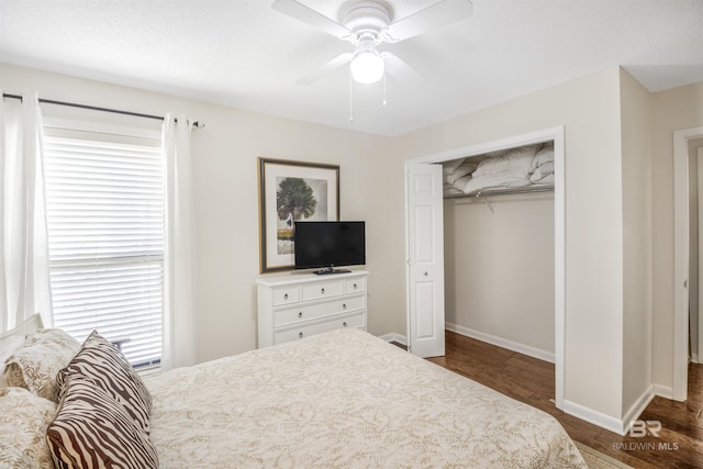 bedroom with ceiling fan, a closet, wood finished floors, and baseboards