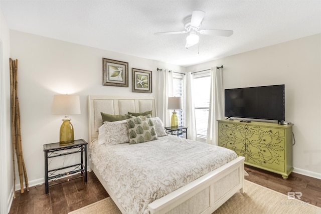 bedroom with a ceiling fan, dark wood finished floors, and baseboards