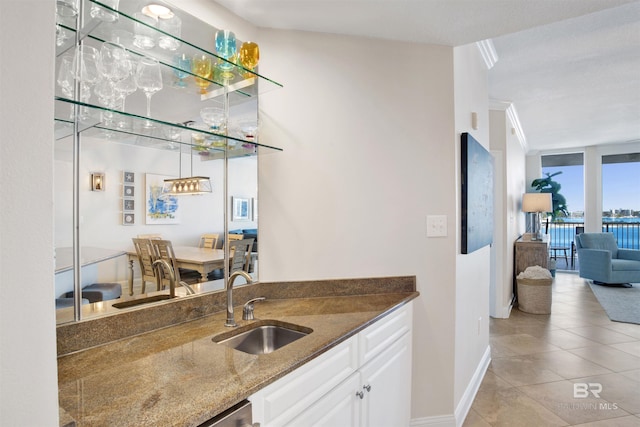 bar featuring light tile patterned floors, expansive windows, a sink, wet bar, and baseboards