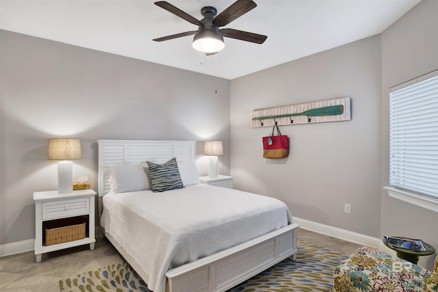 bedroom featuring ceiling fan, multiple windows, and baseboards