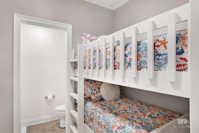 interior space with toilet, tile patterned flooring, and baseboards