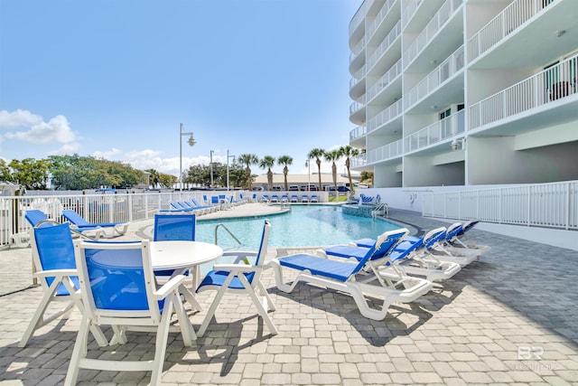 pool with a patio area and fence