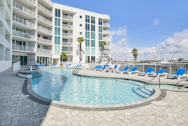 community pool with a patio and fence