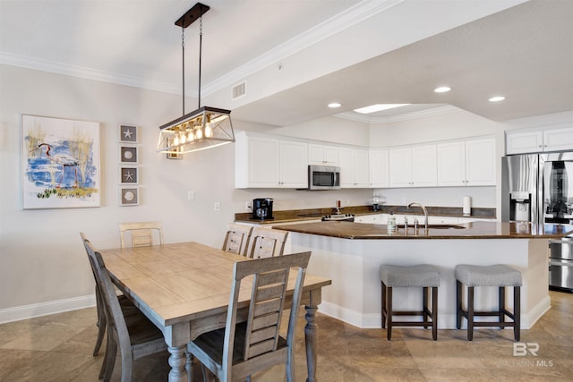 kitchen with ornamental molding, appliances with stainless steel finishes, and a sink