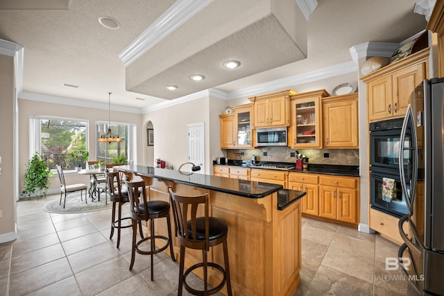 270 Cypress Lake Dr, Gulf Shores, AL 36542 - kitchen with appliances with stainless steel finishes, a kitchen breakfast bar, decorative backsplash, dark countertops, and a center island