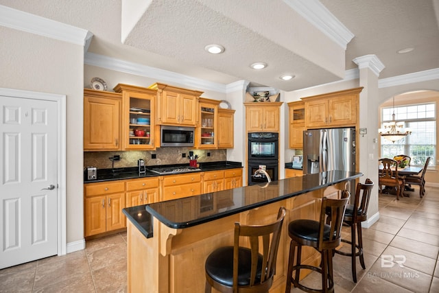 270 Cypress Lake Dr, Gulf Shores, AL 36542 - kitchen featuring stainless steel appliances, ornamental molding, a kitchen breakfast bar, decorative backsplash, and arched walkways