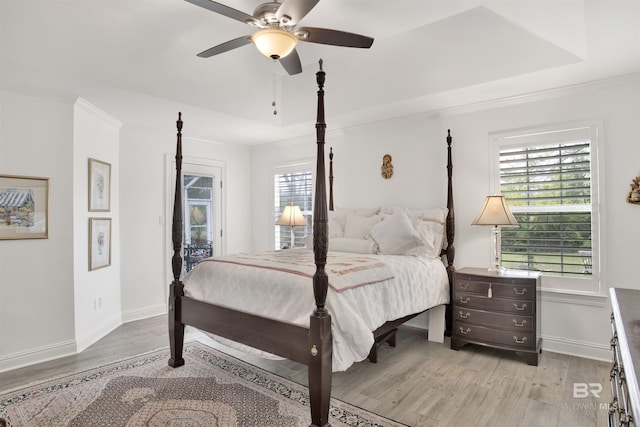 bedroom with a raised ceiling, crown molding, ceiling fan, and light hardwood / wood-style floors