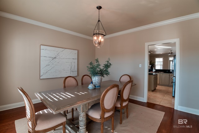 dining room with crown molding, hardwood / wood-style floors, and a notable chandelier