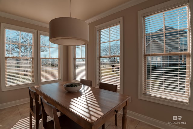 tiled dining area with crown molding and a healthy amount of sunlight