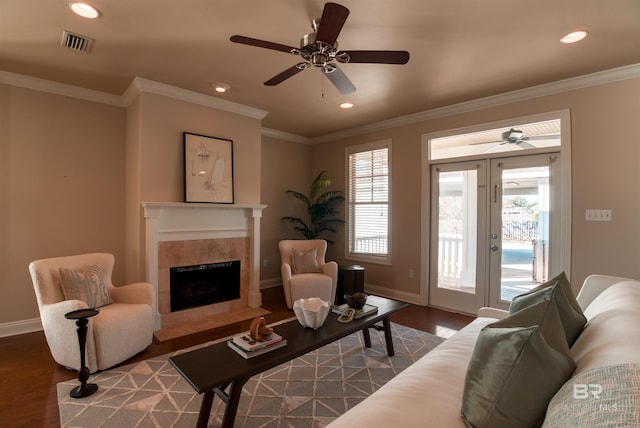 living room with a fireplace, wood-type flooring, ceiling fan, and crown molding