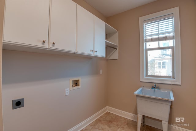 clothes washing area with hookup for an electric dryer, washer hookup, light tile patterned floors, and cabinets