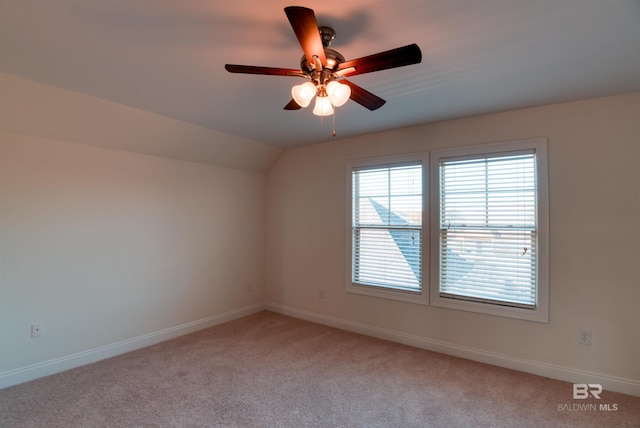 empty room with ceiling fan, light colored carpet, and lofted ceiling