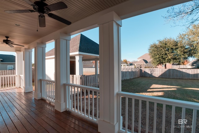 wooden terrace featuring a yard and ceiling fan