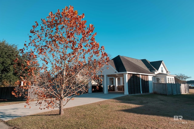 exterior space featuring a carport and a lawn