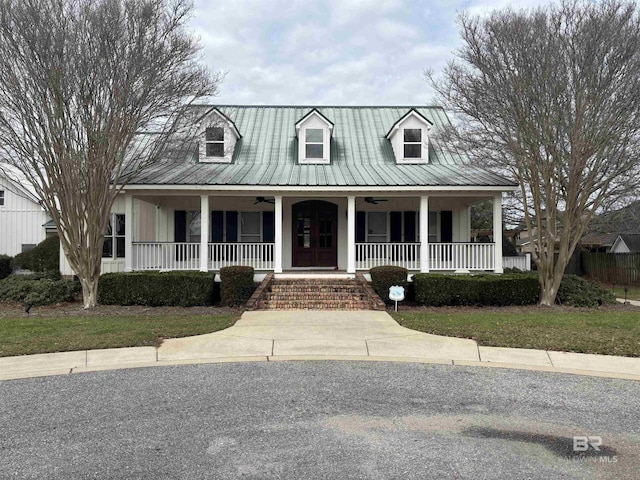 cape cod home featuring covered porch