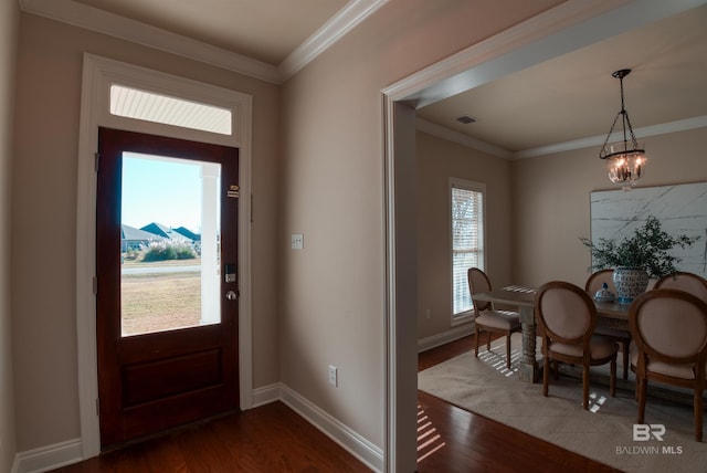 foyer featuring crown molding, dark hardwood / wood-style floors, and a chandelier