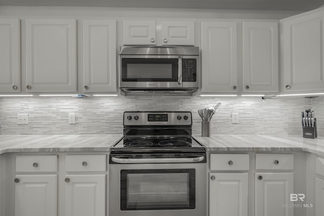 kitchen featuring backsplash, stainless steel appliances, and white cabinets