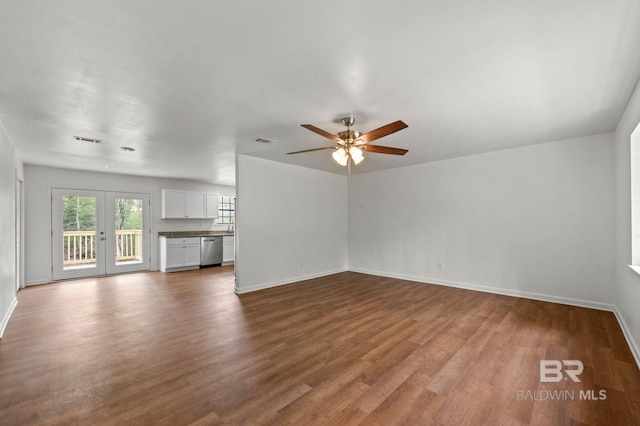 unfurnished living room featuring visible vents, baseboards, and dark wood-style floors