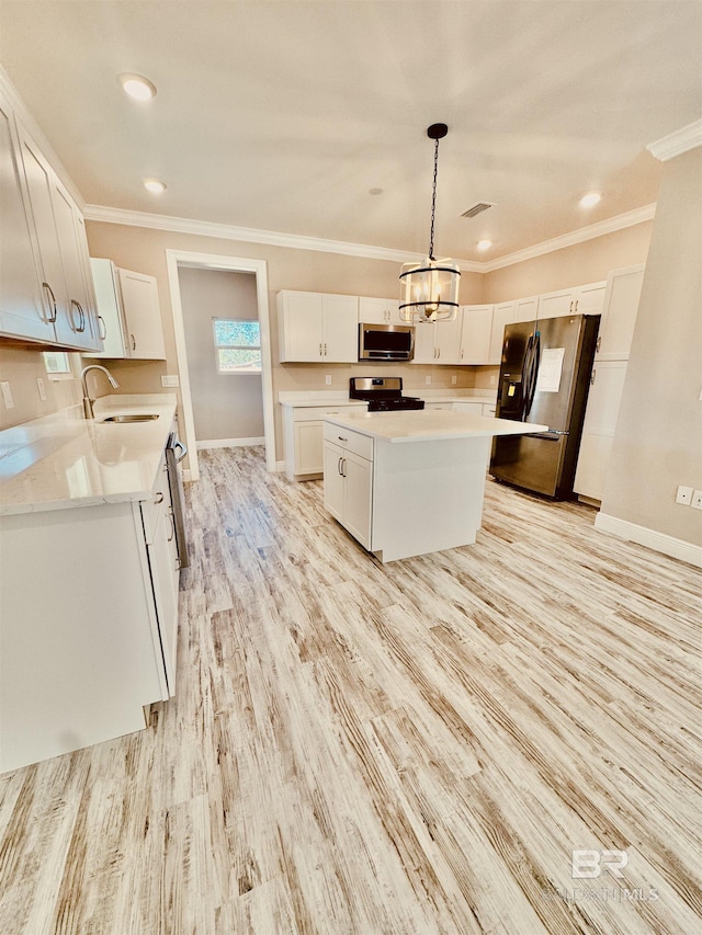 kitchen featuring a kitchen island, appliances with stainless steel finishes, decorative light fixtures, white cabinetry, and light wood-type flooring