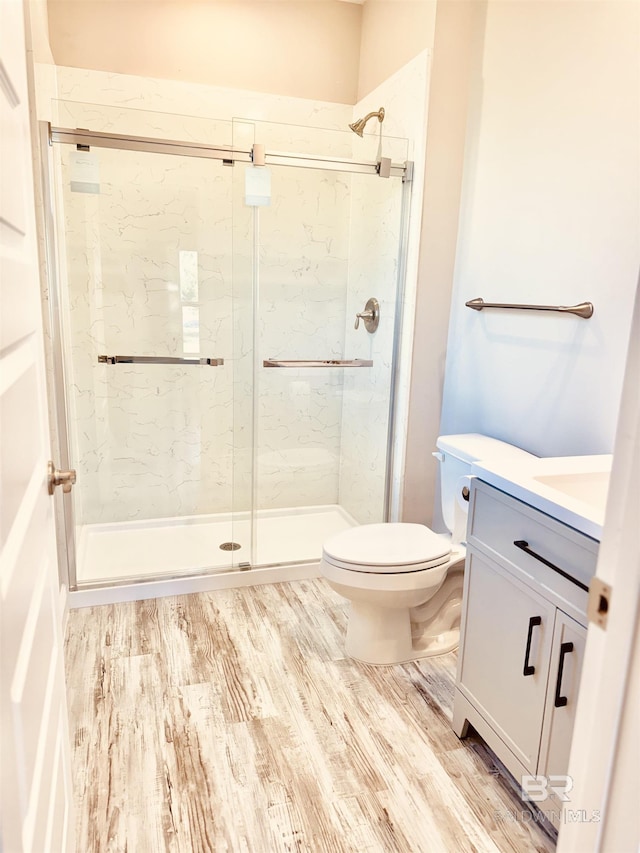 bathroom with vanity, hardwood / wood-style floors, toilet, and walk in shower