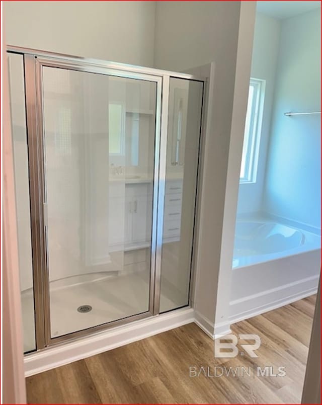 bathroom featuring hardwood / wood-style floors and shower with separate bathtub