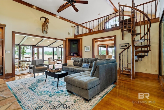 living room featuring hardwood / wood-style flooring, a high ceiling, and ceiling fan