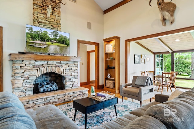 living room with beamed ceiling, high vaulted ceiling, wood-type flooring, and a stone fireplace