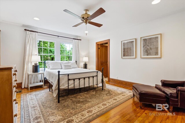 bedroom featuring crown molding, hardwood / wood-style flooring, and ceiling fan