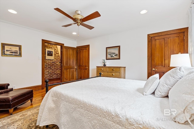 bedroom featuring ceiling fan, light hardwood / wood-style floors, and ornamental molding