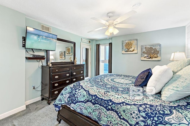 bedroom with a textured ceiling, ceiling fan, and light carpet