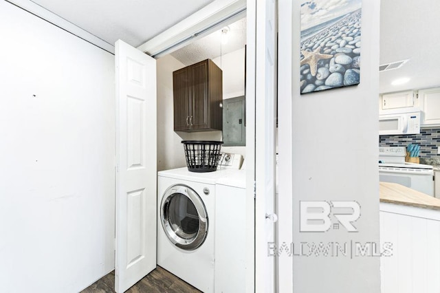 laundry area featuring cabinets, electric panel, dark hardwood / wood-style floors, and washer and clothes dryer