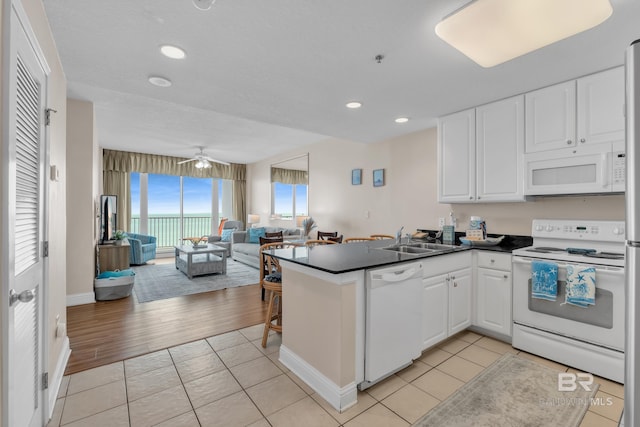 455 E Beach Blvd Unit 511, Gulf Shores, AL 36542 - kitchen with a sink, dark countertops, open floor plan, white appliances, and a peninsula