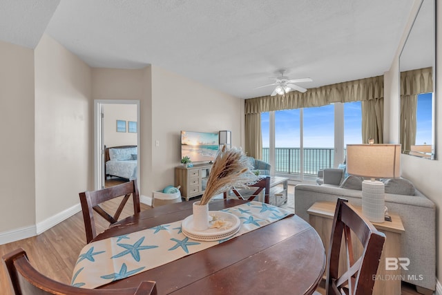 455 E Beach Blvd Unit 511, Gulf Shores, AL 36542 - dining area featuring a ceiling fan, a textured ceiling, wood finished floors, and baseboards