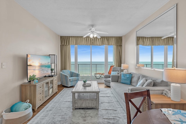 455 E Beach Blvd Unit 511, Gulf Shores, AL 36542 - living room featuring wood finished floors, a healthy amount of sunlight, a water view, and ceiling fan