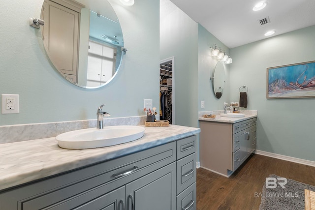 4001 Landfall Dr, Pensacola, FL 32507 - bathroom featuring visible vents, a sink, two vanities, and wood finished floors