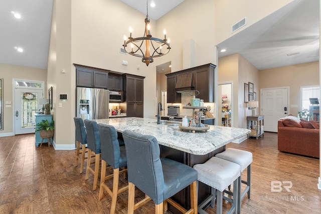 4001 Landfall Dr, Pensacola, FL 32507 - dining area featuring an inviting chandelier, baseboards, a high ceiling, visible vents, and wood finished floors