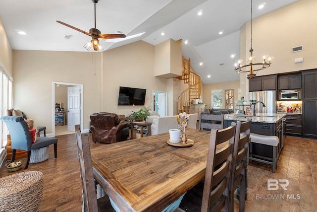 4001 Landfall Dr, Pensacola, FL 32507 - dining space featuring ceiling fan with notable chandelier, visible vents, high vaulted ceiling, and wood finished floors