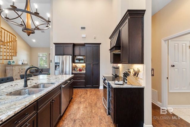 4001 Landfall Dr, Pensacola, FL 32507 - kitchen featuring dark brown cabinetry, a sink, light stone countertops, appliances with stainless steel finishes, and visible vents